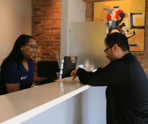 Patient services coordinator at Ravenswood Chiropractic in Andersonville verify's health insurance benefits and reviews chiropractic care plan with patient